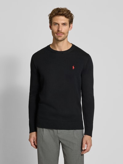 Männermodel trägt schwarzen Relaxed Fit Pullover aus reiner Baumwolle von Polo Ralph Lauren, rote Logo-Stickerei, Ganzkörperansicht von vorne.