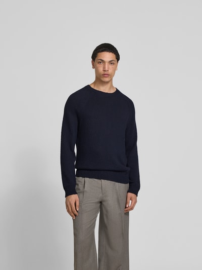 Männermodel trägt Regular Fit Pullover in Strick-Optik von Closed in Dunkelblau, Reine Baumwolle, Rundhalsausschnitt, Ganzkörperansicht von vorne.