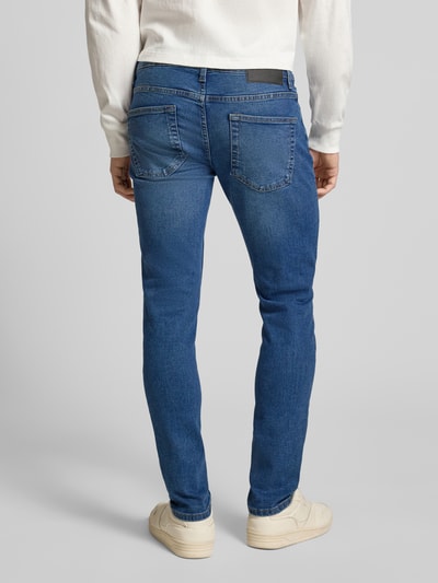 Männermodel trägt Slim Fit Jeans aus Baumwoll-Mix Modell 'LOOM' von Only & Sons in Blau mit Label Patch, 5-Pocket-Design, Ganzkörperansicht Rückansicht.