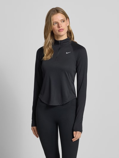 Frauenmodel trägt Funktionsshirt mit Reißverschluss und Logo Modell 'Tempo' von NIKE TRAINING, Slim-Fit, Stehkragen, Schwarz, Ganzkörperansicht von vorne. Rückenlänge bei Größe S: 58 cm.