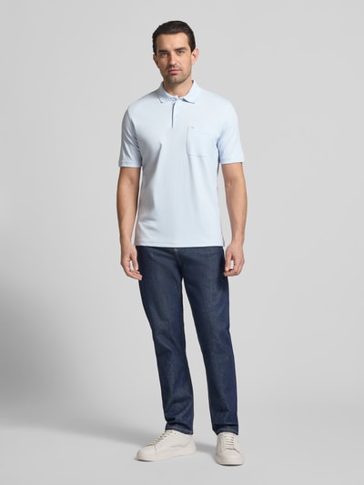 Männermodel trägt Regular Fit Poloshirt mit Brusttasche von Christian Berg Men, Baumwoll-Mix, Polokragen, Knopfleiste, Ganzkörperansicht von vorne.