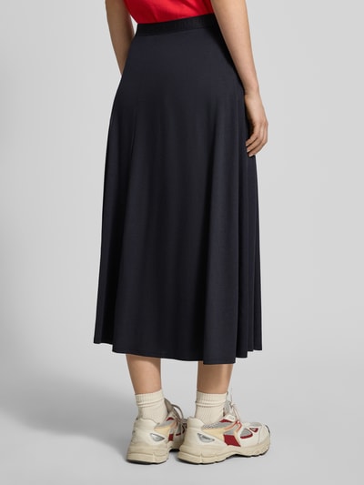 Vrouwenmodel draagt Loose Fit midi-rok uit mix van katoen en lyocell model 'ILENIAA LARAA' van Armedangels, look: effen, fijnribstructuur, elastische band met logostitching, midilengte, labelopschrift, model: loose fit, materiaalverwerking: fijnrib, Ganzkörperansicht Rückansicht.