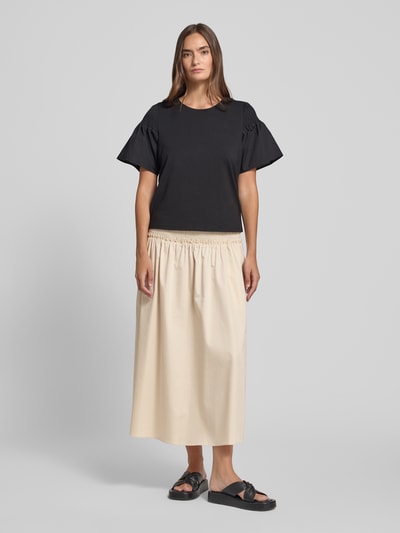 Frauenmodel trägt Midirock mit Smok-Detail von Comma in Beige, A-Linie, aus Elastischer Baumwoll-Mix, Ganzkörperansicht von vorne.