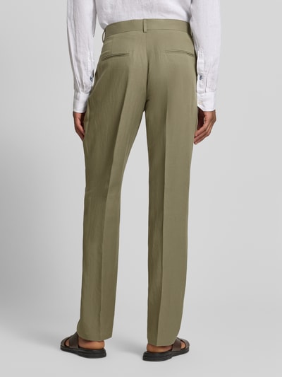 Męski model nosi spodnie materiałowe Straight Fit Stoffhose aus Lyocell-Mix Modell 'Myron' od GUESS w odcieniu oliwkowym z kantami i kieszeniami z tyłu, mieszanka lyocellu i lnu z dodatkiem bawełny, zapięcie na guzik i zamek błyskawiczny, szerokość w rozmiarze 50: 42 cm, długość wewnętrzna nogawki: 107 cm, widok całej sylwetki z tyłu