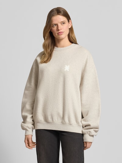 Frauenmodel trägt Sweatshirt mit rückseitigem Statement-Print Modell 'No Hustle' von Karo Kauer aus Reine Baumwolle, Oversized-Fit, Rundhalsausschnitt, überschnittene Schultern, Logo-Print, gerippte Abschlüsse, dezente beige Farbe, glatte Textur, Ganzkörperansicht von vorne.