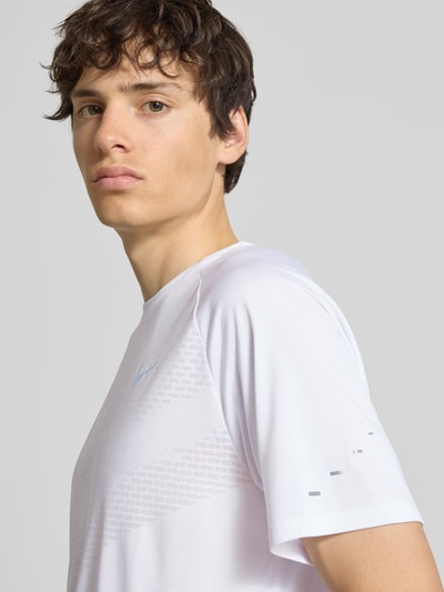 Männermodel trägt Funktionsshirt mit Logo und Rundhalsausschnitt Modell 'Stride' von NIKE TRAINING, weiß, Nahaufnahme Oberkörper.