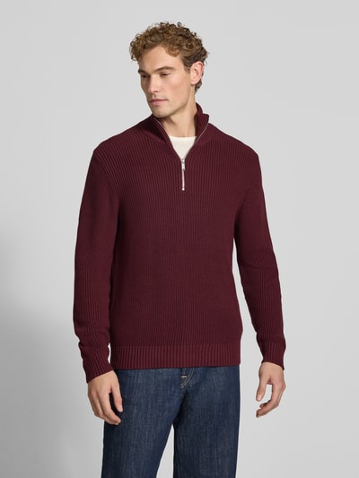 Männermodel trägt Slim Fit Strickpullover aus reiner Baumwolle mit Troyer-Kragen von MCNEAL in Dunkelrot, Ganzkörperansicht von vorne. Rückenlänge 72 cm, Ärmellänge 74 cm, gerippte Abschlüsse, Langarm.