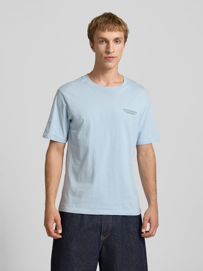 Männermodel trägt T-Shirt mit Label-Print und Rundhalsausschnitt von Jack & Jones in Hellblau, reine Baumwolle, Regular Fit, Ganzkörperansicht von vorne.