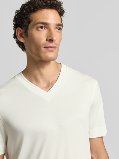Männermodel trägt T-Shirt aus Modal-Mix mit V-Ausschnitt von Emporio Armani in Cremefarbe, Regular Fit, Nahaufnahme Oberkörper.