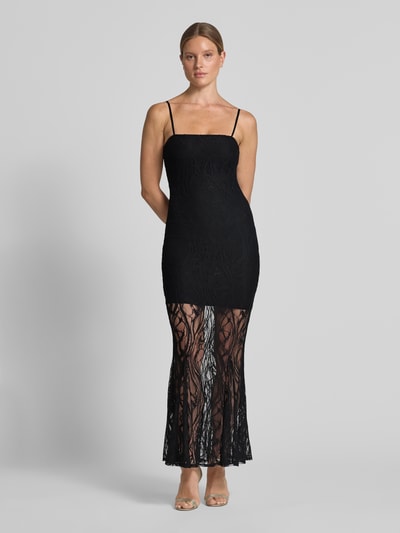 Frauenmodel trägt figurbetontes, schwarzes Maxikleid aus Spitze Modell 'EVELYN' von GUESS mit Spaghettiträgern, Ganzkörperansicht von vorne.