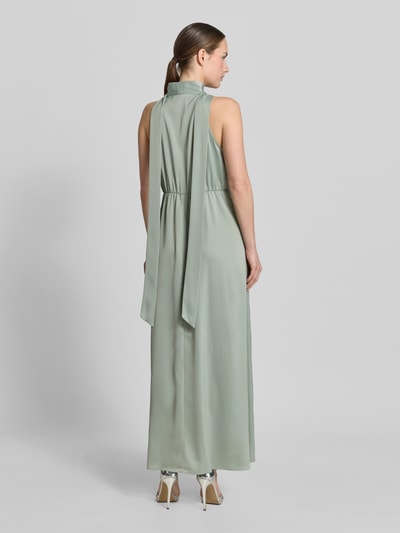 Frauenmodel trägt Maxikleid aus Satin mit Stehkragen Modell 'Thea' von YAS in Pastellgrün, Elastischer-Material-Mix, Taillierte Passform, Ärmelloses-Design, Schlüsselloch-Ausschnitt, Rückenlänge bei Größe 36: 132 cm, Brustweite bei Größe 36: 41 cm, Ganzkörperansicht Rückansicht.