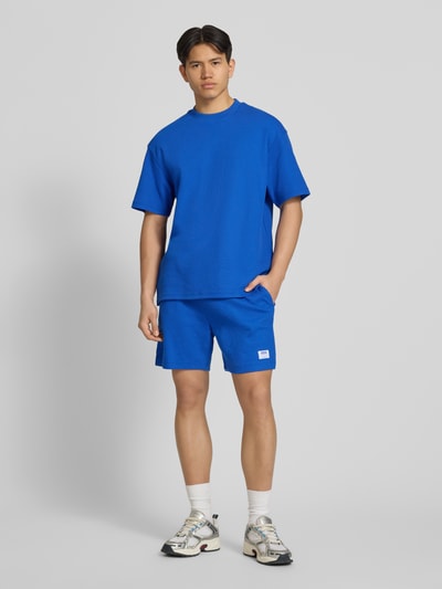 Männermodel trägt Regular Fit Sweatshorts aus Baumwoll-Mix Modell 'NUWAFFLO' von HUGO, Optik: Unifarben, Ganzkörperansicht von vorne.