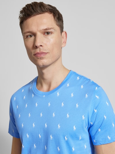 Männermodel trägt Regular Fit Pyjama-Oberteil aus reiner Baumwolle Modell 'CREW-SLEEP-TOP' von Polo Ralph Lauren Underwear, hellblau mit weißem Polo-Pony-Muster, Crew Neck und kurzen Ärmeln, Nahaufnahme Oberkörper.