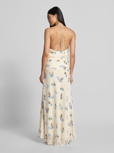Frauenmodel trägt Maxikleid mit Neckholder Modell 'Gabina' von Neo Noir aus cremefarbenem Chiffon mit blauen Blumen, Raffungen, Rückansicht Ganzkörperansicht.