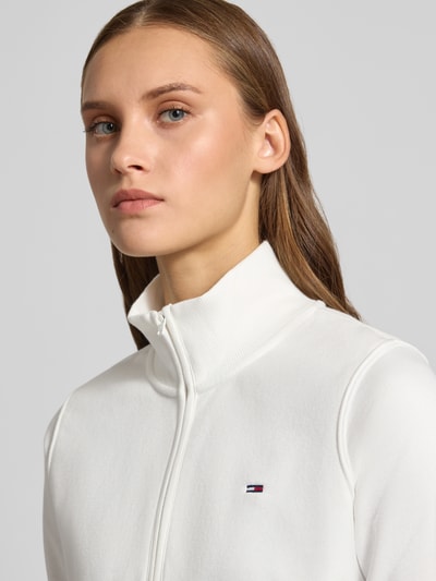 Kobieta nosi Regular Fit Sweatjacke aus Baumwoll-Mix von Tommy Jeans, biała tkanina, drobna faktura, zbliżenie górnej części ciała
