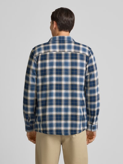 Męski model nosi Relaxed Fit Freizeithemd mit Brusttaschen od Fynch-Hatton, koszula casualowa z bawełny, wzór w kratę, kołnierzyk typu kent, długość tyłu 78 cm przy rozmiarze M, długie rękawy, sportowe mankiety, listwa guzikowa, widok całej sylwetki z tyłu.