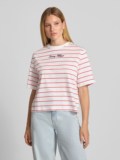 Frauenmodel trägt Regular Fit T-Shirt aus reiner Baumwolle von Tommy Hilfiger mit weißen, roten Streifen, weicher Textur, Nahaufnahme Oberkörper. Damen T-Shirt von Tommy Hilfiger.