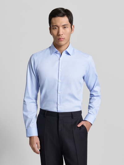 Männermodel trägt Regular Fit Business Hemd aus Baumwolle mit Kentkragen von Jake*s in Hellblau, Knopfleiste, Ganzkörperansicht von vorne.