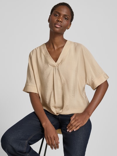 Frauenmodel trägt Blusenshirt mit V-Ausschnitt von Christian Berg Woman in Beige, leichte Drapierung, 1/2-Arm, Regular Fit, Nahaufnahme Oberkörper.