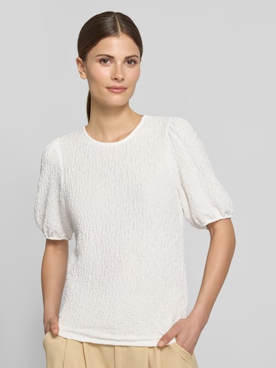 Frauenmodel trägt Blusenshirt mit Strukturmuster Modell 'FALL' von Vila, Material-Mix mit Stretch-Anteil, Regular-Fit, Rundhalsausschnitt, Ganzkörperansicht von vorne. Rückenlänge bei Größe S: 53 cm, Ärmellänge bei Größe S: 31 cm. Helle Farbe, weiche strukturierte Oberfläche, kurze Ärmel.