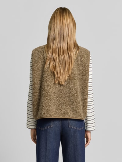 Frauenmodel trägt Regular Fit Weste aus Teddyfell Modell 'Hoktown' von American Vintage in Beige mit Logo-Patch, Ganzkörperansicht Rückansicht. Rückenlänge, Schulterbreite und Brustweite bei Größe XS/S laut Kontext.