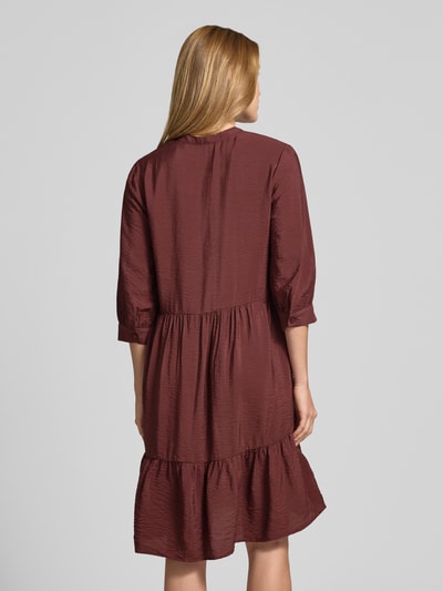 Frauenmodel trägt Relaxed Fit Midikleid aus Viskose-Mix mit Tunika-Ausschnitt von Christian Berg Woman in Braunton, strukturierte Oberfläche, Halbarm, Knopfleiste, Ganzkörperansicht Rückansicht, Rückenlänge bei Größe 36: 106 cm, Brustweite bei Größe 36: 45 cm, Ärmellänge bei Größe 36: 44 cm.