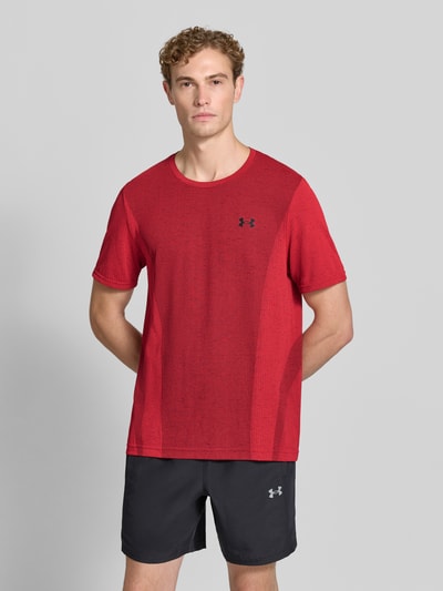 Männermodel trägt Regular Fit Sport-T-Shirt mit Logo-Print von Under Armour in Rot und schwarze Shorts, Nahaufnahme Oberkörper, Herren Sport-T-Shirt von Under Armour.