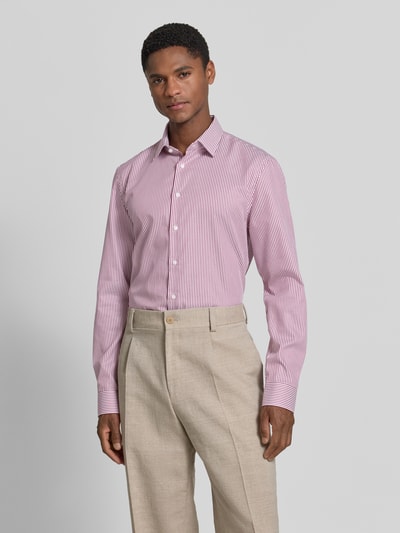Männermodel trägt Slim Fit Business-Hemd mit Kentkragen von Jake*s aus Reine Baumwolle, schmale Streifen, Knopfleiste, Sportmanschetten, helle Hose, sanfte Farben, glatte Textur, Ganzkörperansicht von vorne. Rückenlänge 78 cm, Schulterbreite 47 cm, Ärmellänge 66 cm bei Größe 39/40.