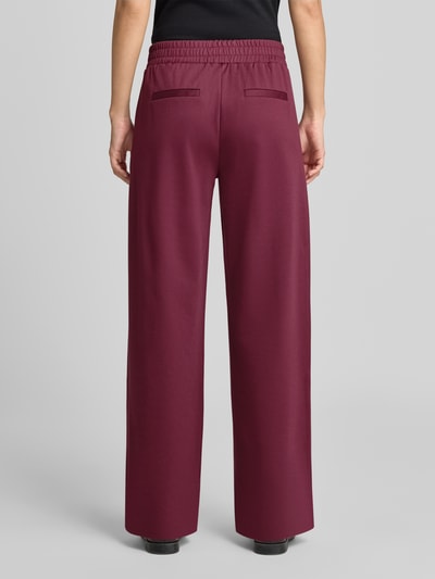 Frauenmodel trägt Wide Fit Hose mit Viskose-Anteil Modell 'Rizetta' von b.young, weinrot, elastischer Bund, glatte Oberfläche, Ganzkörperansicht Rückansicht.