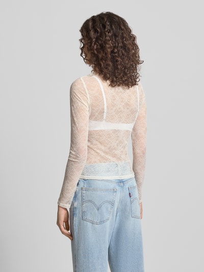 Frauenmodel trägt Longsleeve mit Cut Out von Gina Tricot in Creme mit Spitze, semitransparent, Material-Mix, Rückenansicht, Ganzkörperansicht.