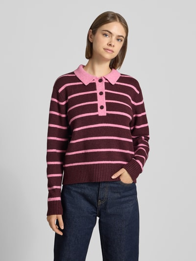 Frauenmodel trägt sweter z dzianiny Strickpullover mit Polokragen Modell 'RUBY' von JJXX, mieszanka materiałów z mieszanką bawełny, luźny krój, kołnierzyk polo, prążkowane wykończenia, długość tyłu w rozmiarze S: 48 cm, długość rękawów w rozmiarze S: 59 cm, poziome paski w odcieniach bordo i różu, tekstura miękka, Ganzkörperansicht von vorne