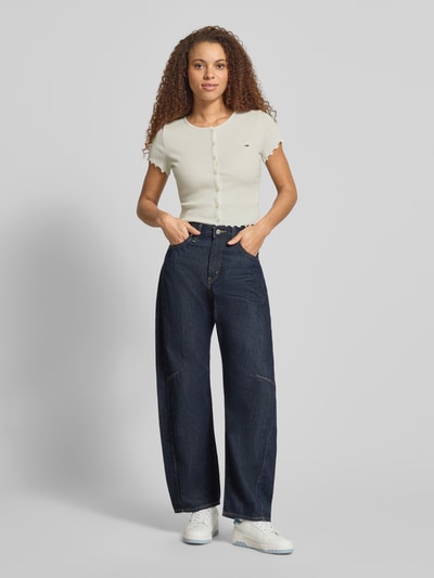 Frauenmodel trägt Slim Fit T-Shirt aus Baumwoll-Mix von Tommy Jeans, Optik: Unifarben, Logo-Stitching, U-Boot-Ausschnitt, Ripp, Ganzkörperansicht von vorne.