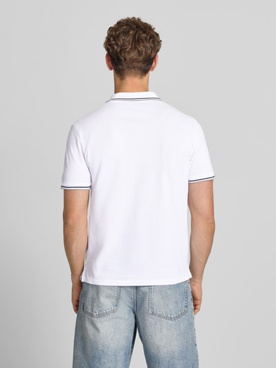Männermodel trägt Slim Fit Poloshirt mit Label-Stitching von CHAMPION in Weiß, reine Baumwolle, Rückenlänge 73 cm, Ganzkörperansicht Rückansicht.