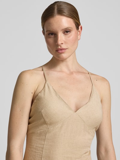 Frauenmodel trägt Regular Fit Leinenkleid mit Viskose-Anteil von Rinascimento in Beige mit Spaghetti-Trägern, V-Ausschnitt, Nahaufnahme Oberkörper.