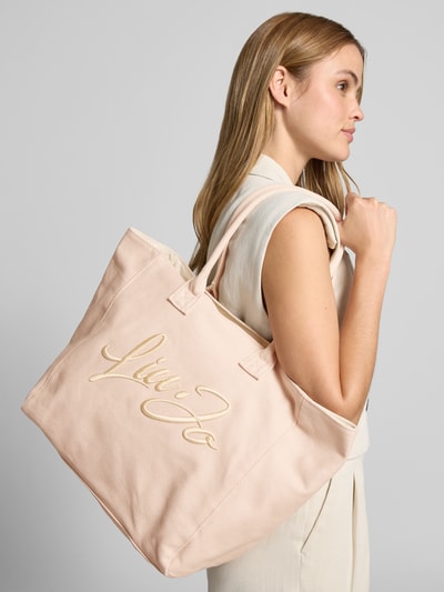 Vrouwenmodel draagt Shopper met Label-Stitching model 'PLENTIA' van Liu Jo White, katoen, lichtbeige, hoofdvak met rits, zijaanzicht, detailopname