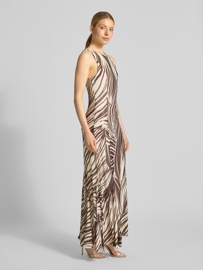 Frauenmodel trägt Maxikleid mit rückseitigem Schlüsselloch-Ausschnitt von Guess, braunes Palmenmuster, Stretch-Material, Ganzkörperansicht von vorne.