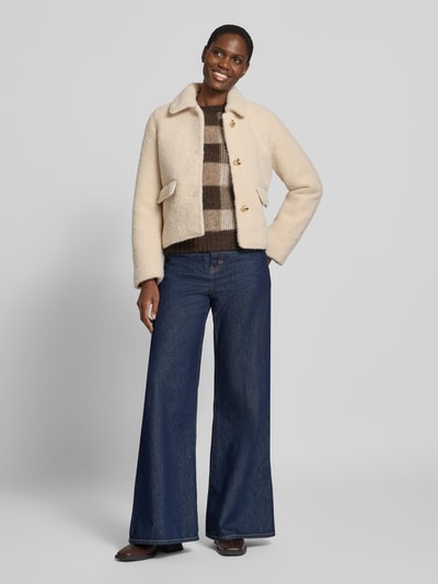 Vrouwenmodel draagt Teddyjacke mit goldfarbenen Zierknöpfen van VERO MODA, look: effen, applicatie: sierknopen, kraagmodel: platte kraag, mouwvorm: lange mouw, sluiting: enkelvoudige knoopsluiting, zakken: klepzakken, Ganzkörperansicht van voren.