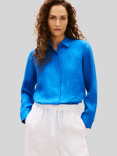 Frauenmodel trägt Relaxed Fit Langarmbluse aus reinem Leinen von Tommy Hilfiger in leuchtend Blau, Optik: Unifarben, Passform: Relaxed-Fit, Hemdkragen, Logo-Stitching, Verschluss: Knopfleiste, Ärmelform: Langarm, Ärmelabschluss: Manschette, Rumpfabschluss: abgerundet, Materialverarbeitung: Flammgarn, Material: Leinen, Ganzkörperansicht von vorne.