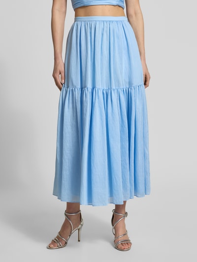 Frauenmodel trägt Maxirock mit Volantsaum und seitlichem Reißverschluss von Jake*s Cocktail in Hellblau, A-Linie, Ganzkörperansicht von vorne. Bundweite 35 cm, Gesamtlänge 90 cm bei Größe 36.