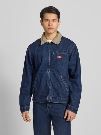 Männermodel trägt Jeansjacke mit Label-Detail und Reißverschluss von Dickies, Reine Baumwolle, Regular-Fit, Umlegekragen, Eingrifftaschen, Ganzkörperansicht von vorne.