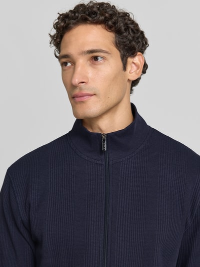 Männermodel trägt Regular Fit Sweatjacke aus Baumwoll-Mix Modell 'Structure' von BOSS in Dunkelblau mit feiner Struktur, Nahaufnahme Oberkörper. Herren Sweatjacke von BOSS.