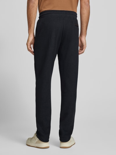 Männermodel trägt Sweatpants mit elastischem Bund und Tunnelzug von bugatti in Schwarz, Baumwoll-Mix, Regular Fit, Ganzkörperansicht Rückansicht.