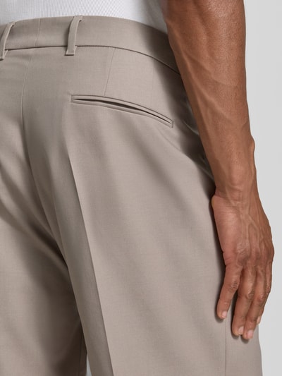 Männermodel trägt Wide Fit Hose mit Bügelfalten von Drykorn, Baumwoll-Mix mit Stretch-Anteil, Gesäßtaschen, Nahaufnahme Rückansicht.