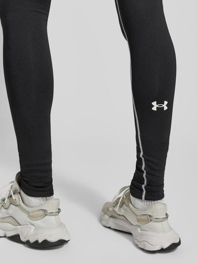 Männermodel trägt Leggings mit elastischem Bund und Label-Details von Under Armour, Material-Mix mit Stretch-Anteil, Nahaufnahme Unterschenkel.