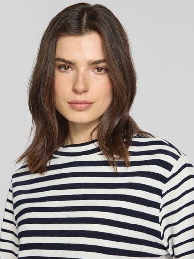 Vrouwenmodel draagt Boxy Fit Pullover uit zuivere katoen van s.Oliver RED LABEL in gestreept wit-marine, crew neck, ribbreisel, label stitching, detailopname bovenlichaam.