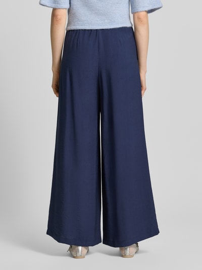 Modelka nosi Wide Fit Stoffhose aus Viskose-Mix Modell 'Frencis' od STEHMANN, granatowy, z elastycznym pasem i kieszeniami, Szerokość w rozmiarze 36: 38 cm, długość wewnętrzna nogawki 77 cm, widok całej sylwetki z tyłu.