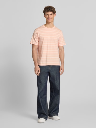 Männermodel trägt T-Shirt mit Streifenmuster und Label-Stitching von Jack & Jones, Reine Baumwolle, Relaxed-Fit, Rundhalsausschnitt, Ganzkörperansicht von vorne.