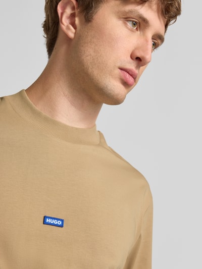 Männermodel trägt Regular Fit T-Shirt aus reiner Baumwolle Modell 'NIEROS' von HUGO in Beige, glatte Struktur, Nahaufnahme Oberkörper, Herren T-Shirt von HUGO Blue.