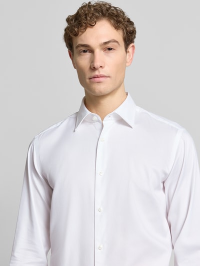 Männermodel trägt Regular Fit Freizeithemd aus Baumwoll-Mix Modell 'H-JOE-K-C1-261' von BOSS in Weiß, Nahaufnahme Oberkörper.