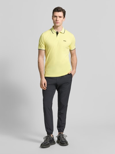 Männermodel trägt Slim Fit Poloshirt aus reiner Baumwolle Modell 'PAUL' von BOSS Green, Optik: Unifarben, Ganzkörperansicht von vorne.